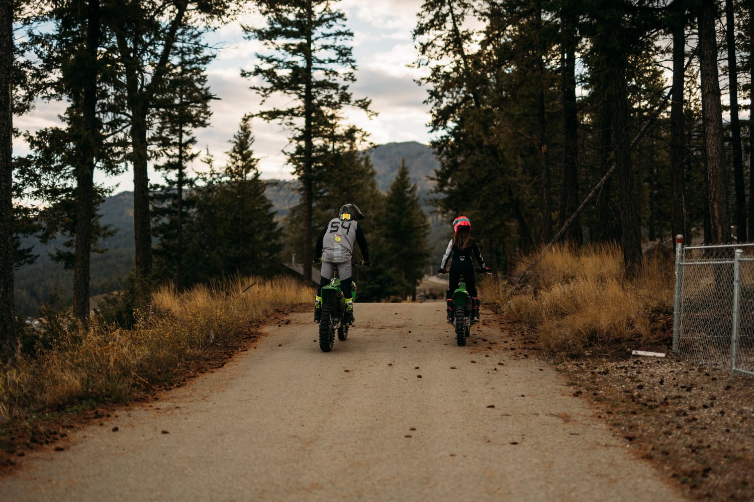 Rachel and Ryan portraits story frame 6: Okanagan couples portraits with dirt bikes, lake and mountain views, autumn sun, standing portraits and champagne celebration.