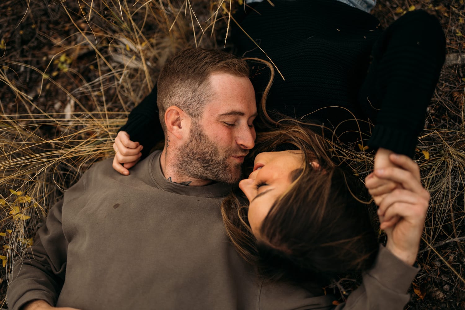 Rachel and Ryan portraits story frame 8: Okanagan couples portraits with dirt bikes, lake and mountain views, autumn sun, standing portraits and champagne celebration.