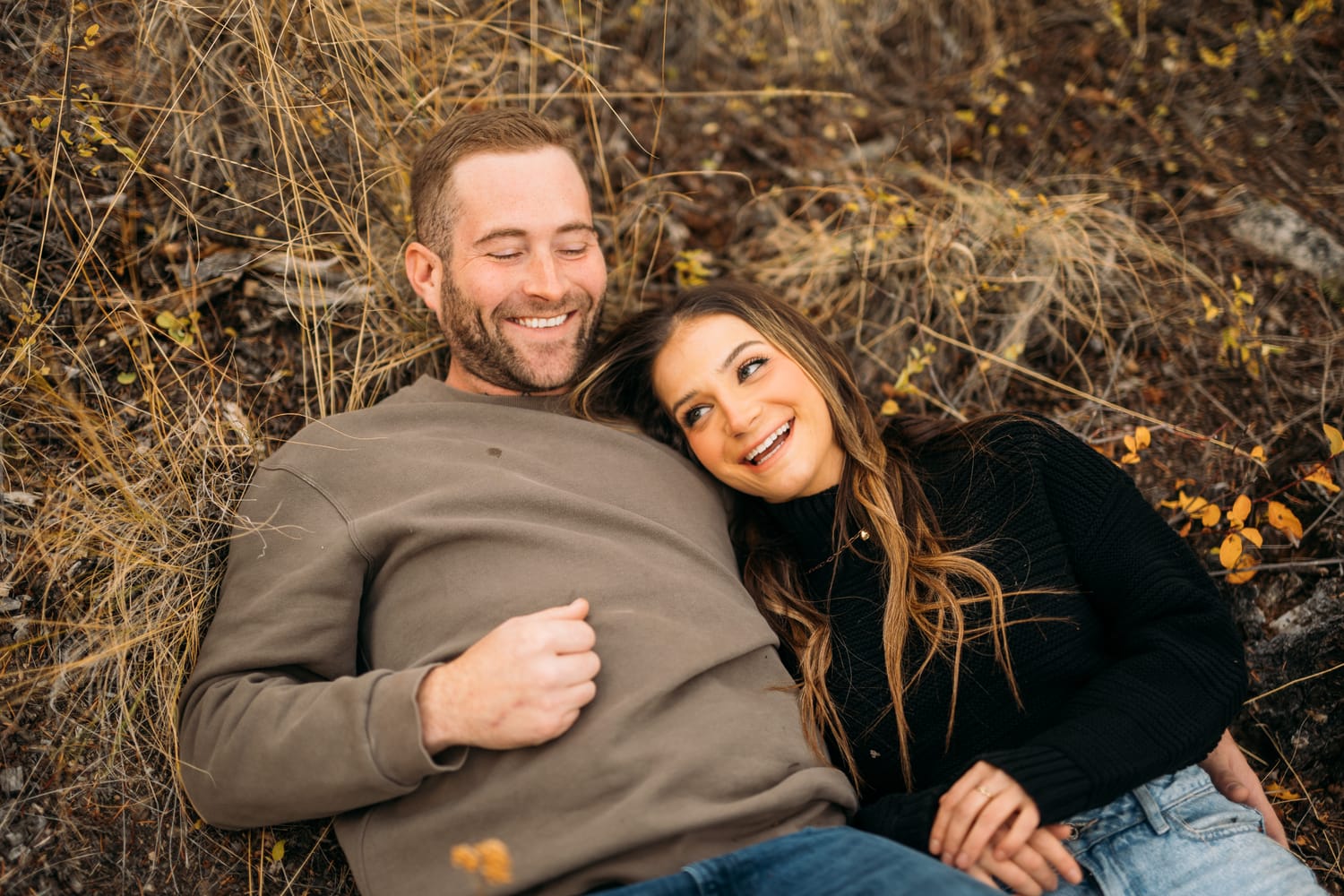 Rachel and Ryan portraits story frame 9: Okanagan couples portraits with dirt bikes, lake and mountain views, autumn sun, standing portraits and champagne celebration.