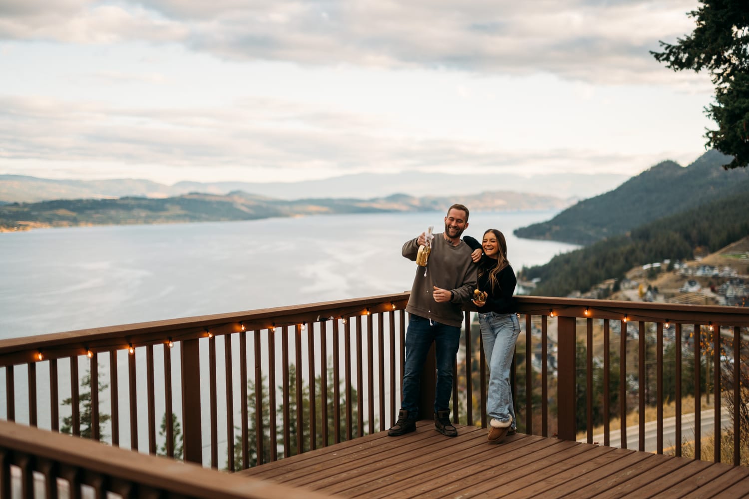 Rachel and Ryan portraits story frame 11: Okanagan couples portraits with dirt bikes, lake and mountain views, autumn sun, standing portraits and champagne celebration.