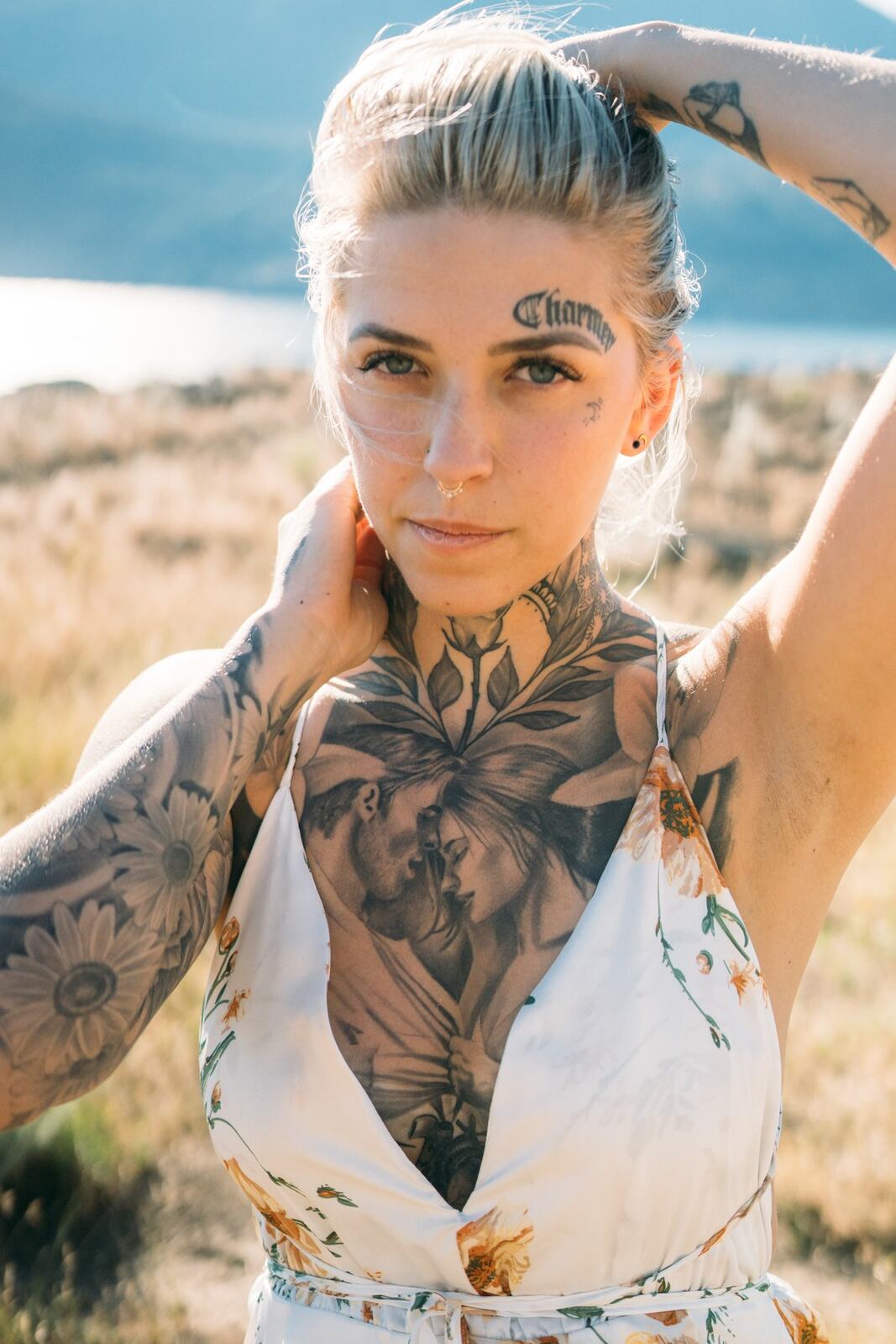 Rayleigh by Knox portraits story frame 3: Knox Mountain portraits in Kelowna with white floral dress, tattoo detail, reeds, water, sunlight and a stronger summer edge.