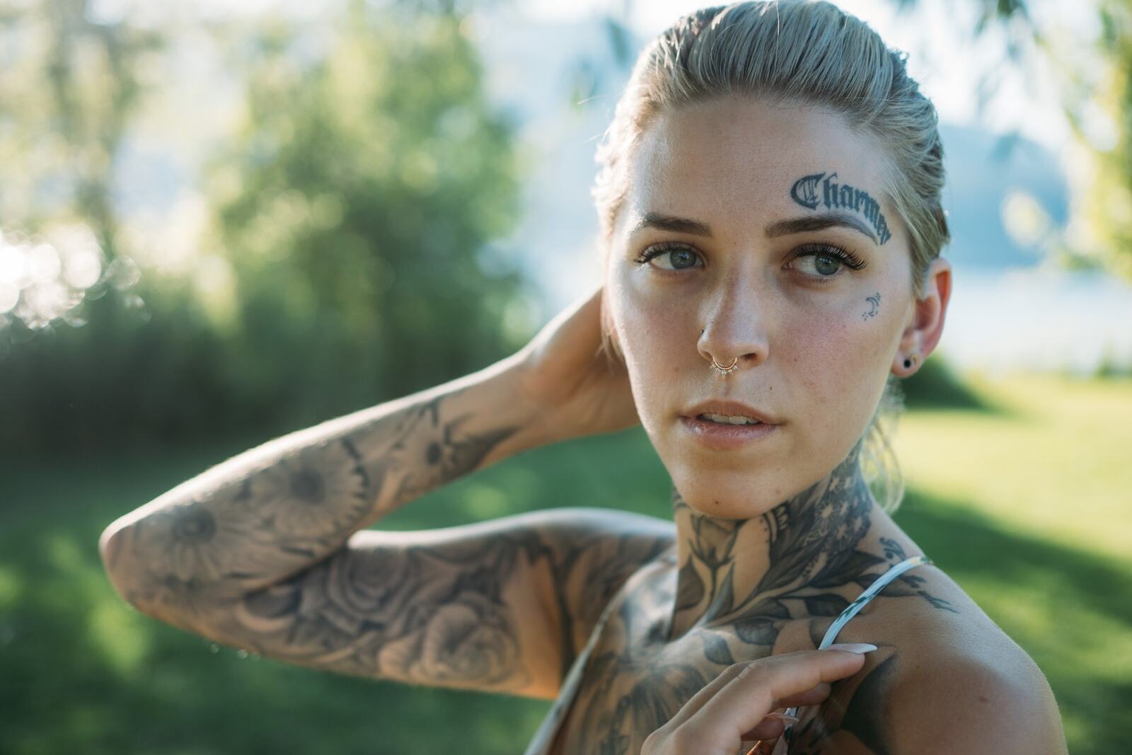 Rayleigh by Knox portraits story frame 5: Knox Mountain portraits in Kelowna with white floral dress, tattoo detail, reeds, water, sunlight and a stronger summer edge.