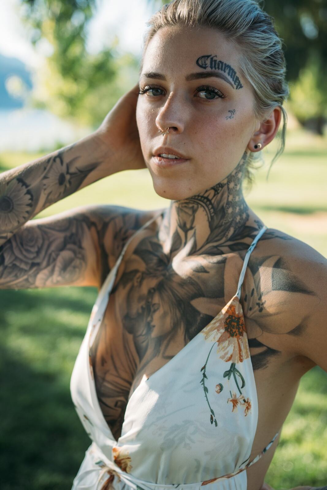Rayleigh by Knox portraits story frame 6: Knox Mountain portraits in Kelowna with white floral dress, tattoo detail, reeds, water, sunlight and a stronger summer edge.