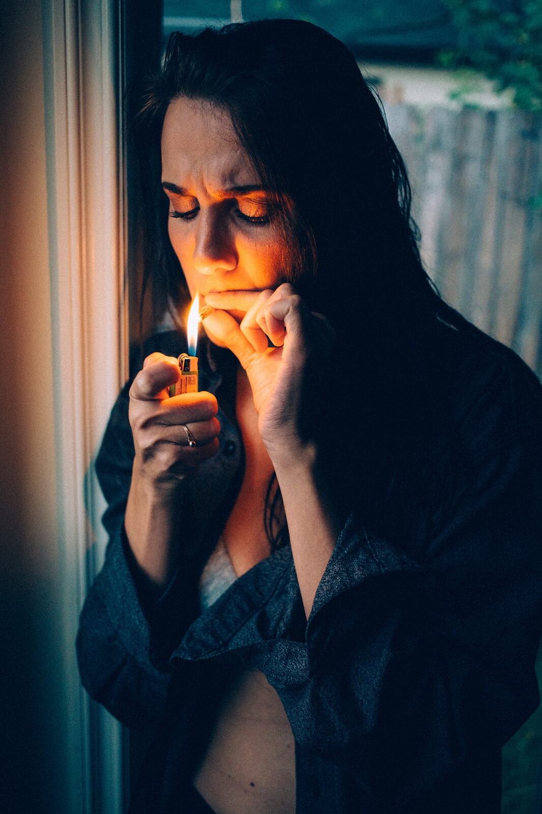 Rebecca in Smoke portraits story frame 18: A dark Kelowna portrait story for Rebecca with window light, smoke, denim, close expression and a low-key editorial mood.