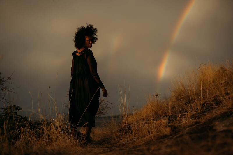 Rebekah stands small beneath a tense break of rainbow and storm light over Okanagan Lake in Kelowna. print option