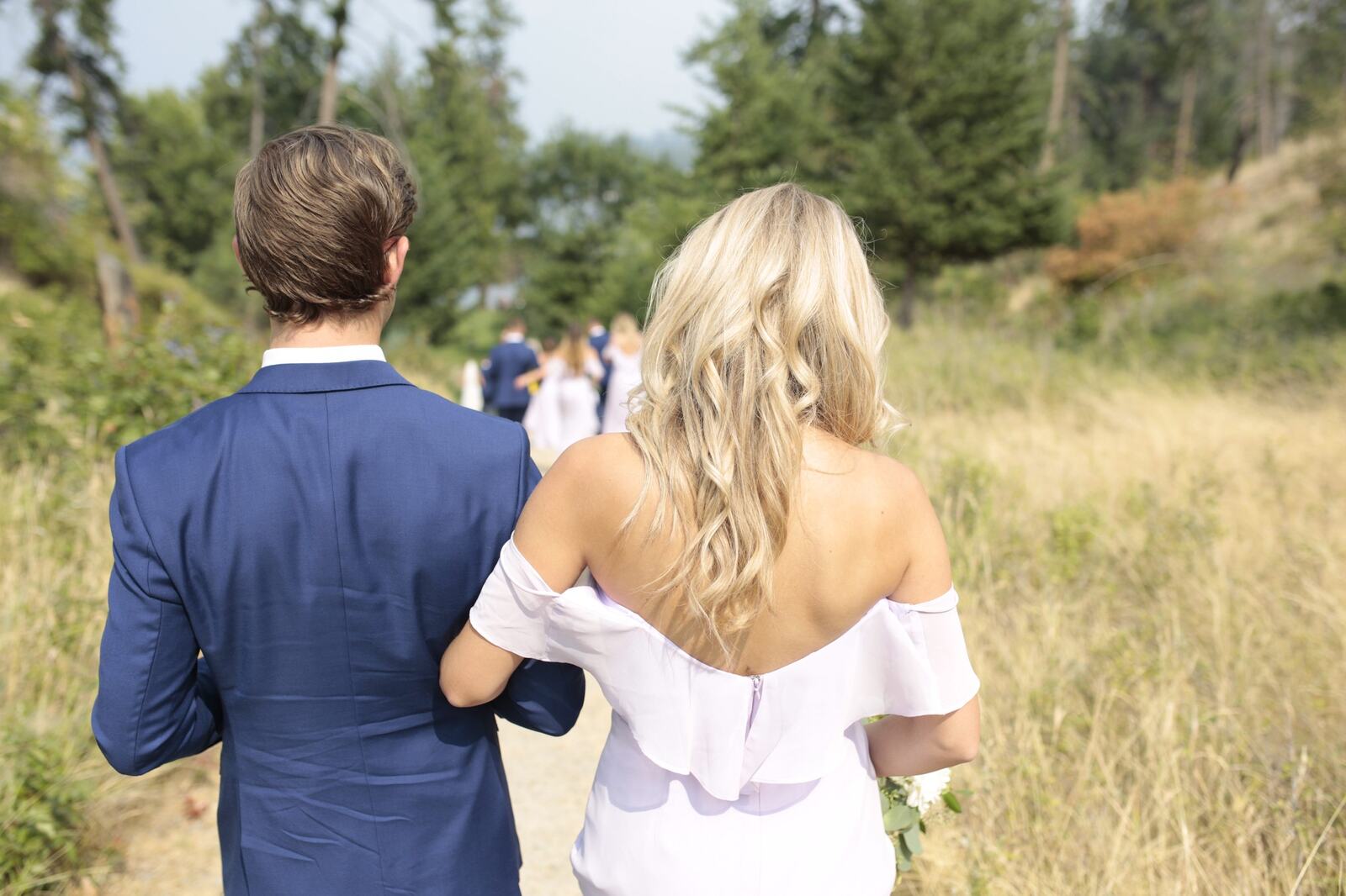 The wedding party walking toward the lakeside portraits