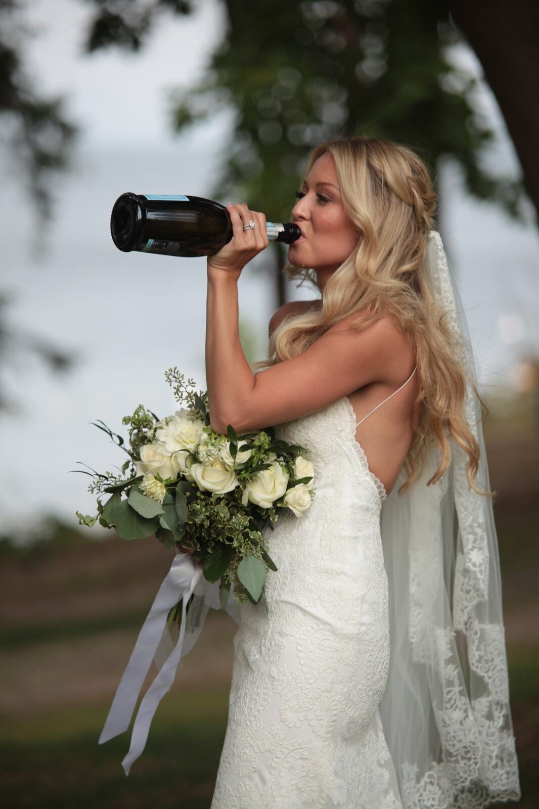 A playful bridal portrait of Sarah beside the lake