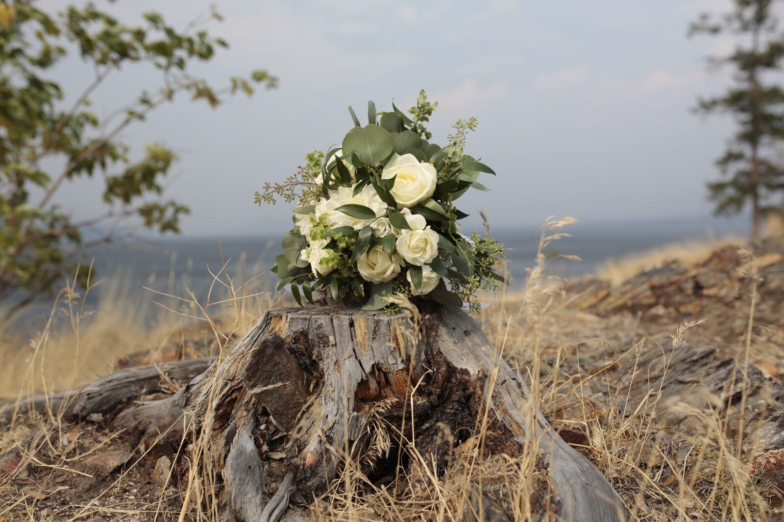 Sarah and Greg with the bouquet in the lakeside landscape