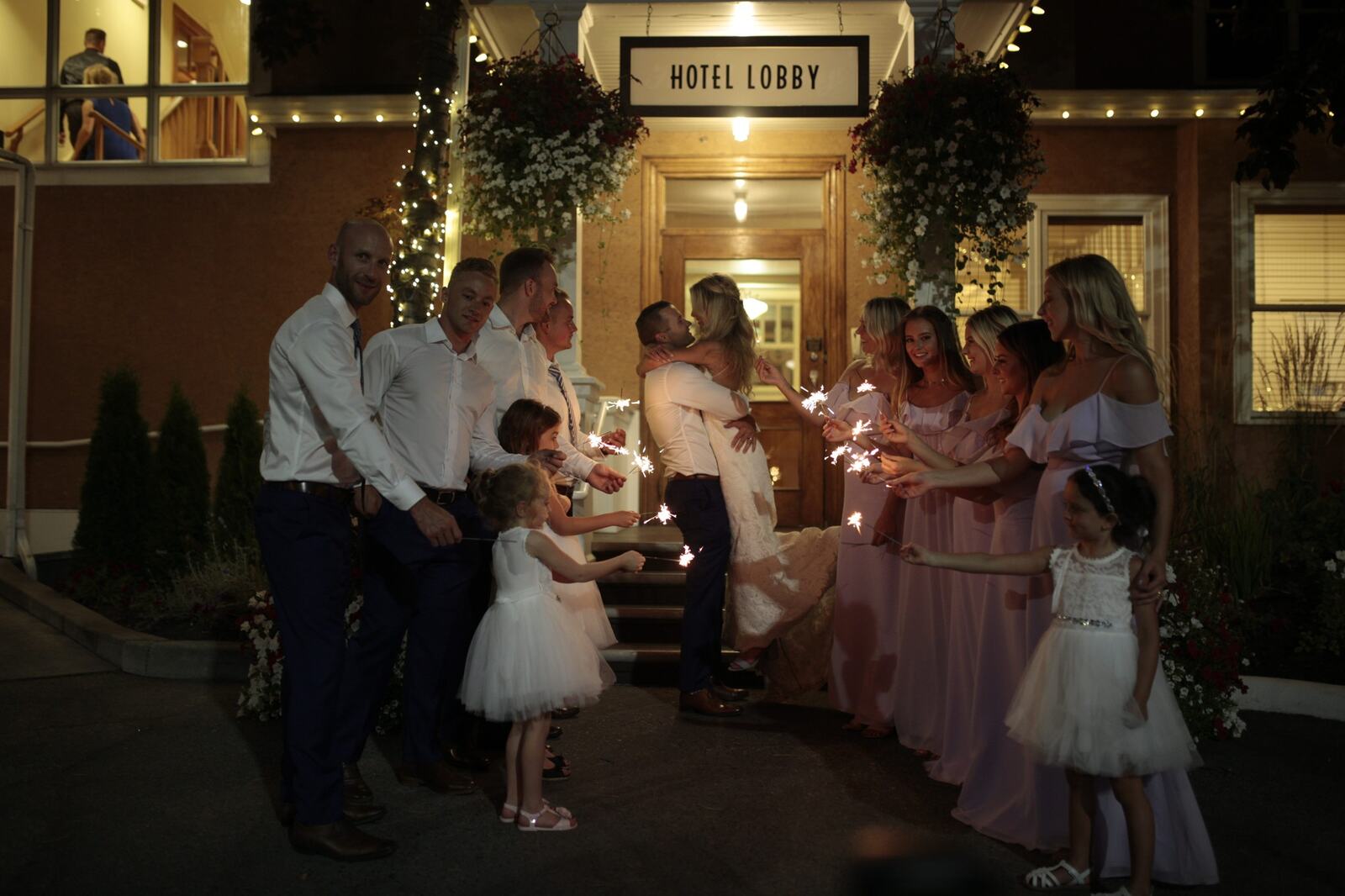 Sarah and Greg surrounded by friends holding sparklers