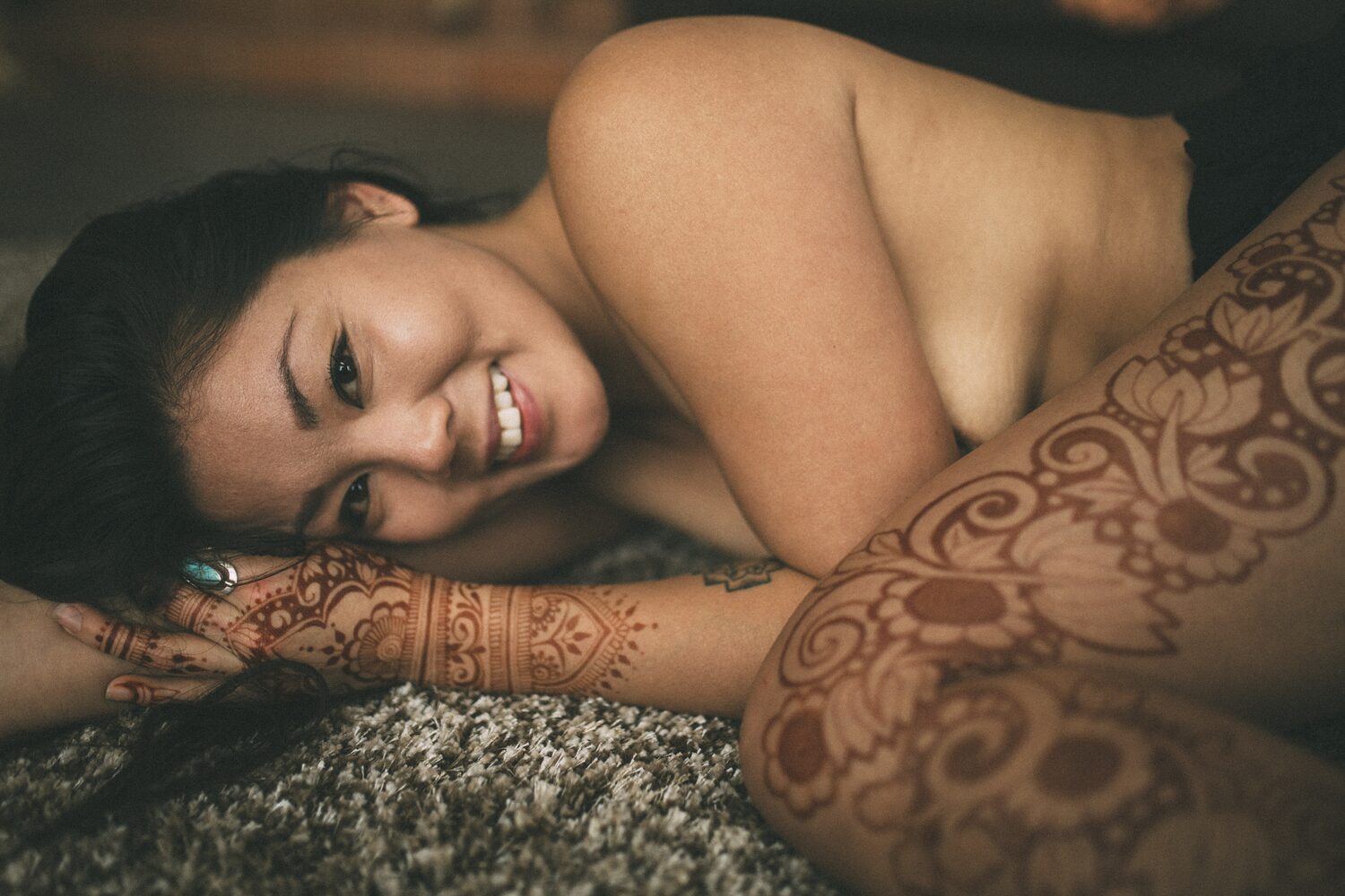 Sarah: Henna, Snow and Candlelight portraits story frame 5: A four-part portrait story with Sarah in Kelowna, moving from a living-room henna session into snow, a daylight coconut-milk bath and a candlelit bath.