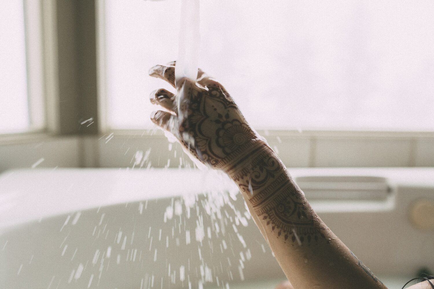 Sarah: Henna, Snow and Candlelight portraits story frame 23: A four-part portrait story with Sarah in Kelowna, moving from a living-room henna session into snow, a daylight coconut-milk bath and a candlelit bath.