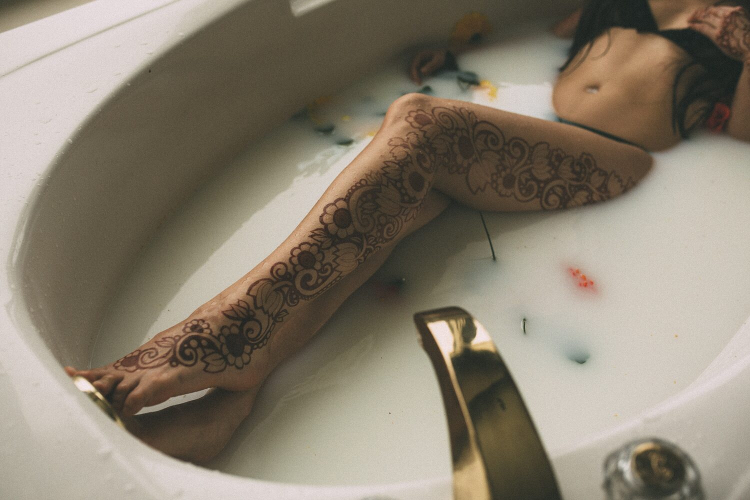 Sarah: Henna, Snow and Candlelight portraits story frame 24: A four-part portrait story with Sarah in Kelowna, moving from a living-room henna session into snow, a daylight coconut-milk bath and a candlelit bath.