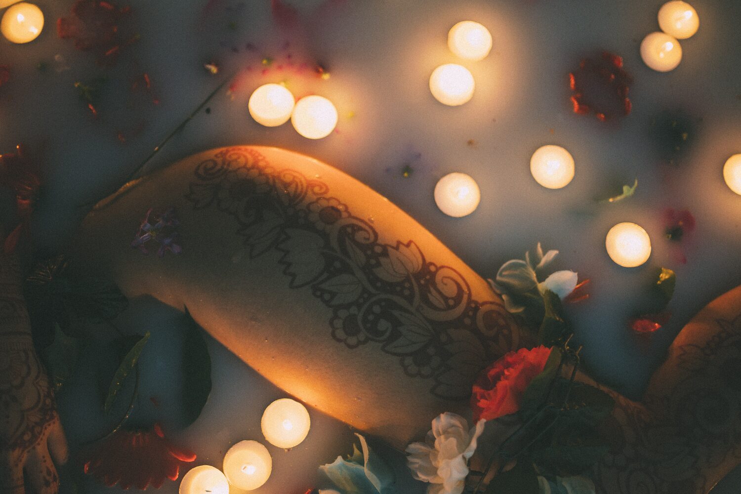 Sarah: Henna, Snow and Candlelight portraits story frame 26: A four-part portrait story with Sarah in Kelowna, moving from a living-room henna session into snow, a daylight coconut-milk bath and a candlelit bath.
