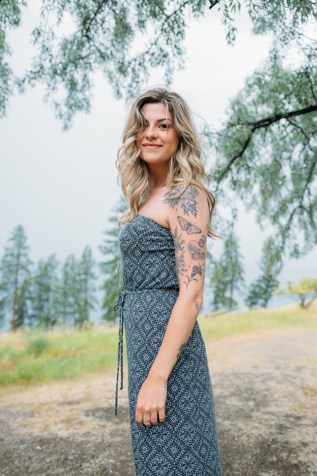 Sophia by the Lake portraits story frame 1: A multi-outfit Okanagan location session with water, trees, shoreline, denim and red swimwear woven into a summer portrait story.