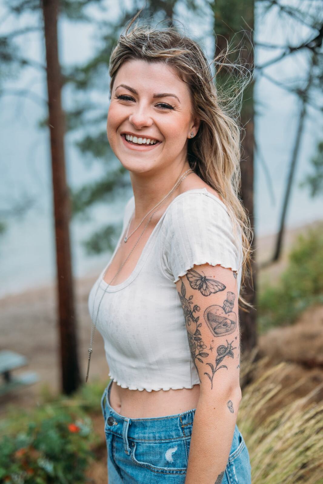 Sophia by the Lake portraits story frame 9: A multi-outfit Okanagan location session with water, trees, shoreline, denim and red swimwear woven into a summer portrait story.