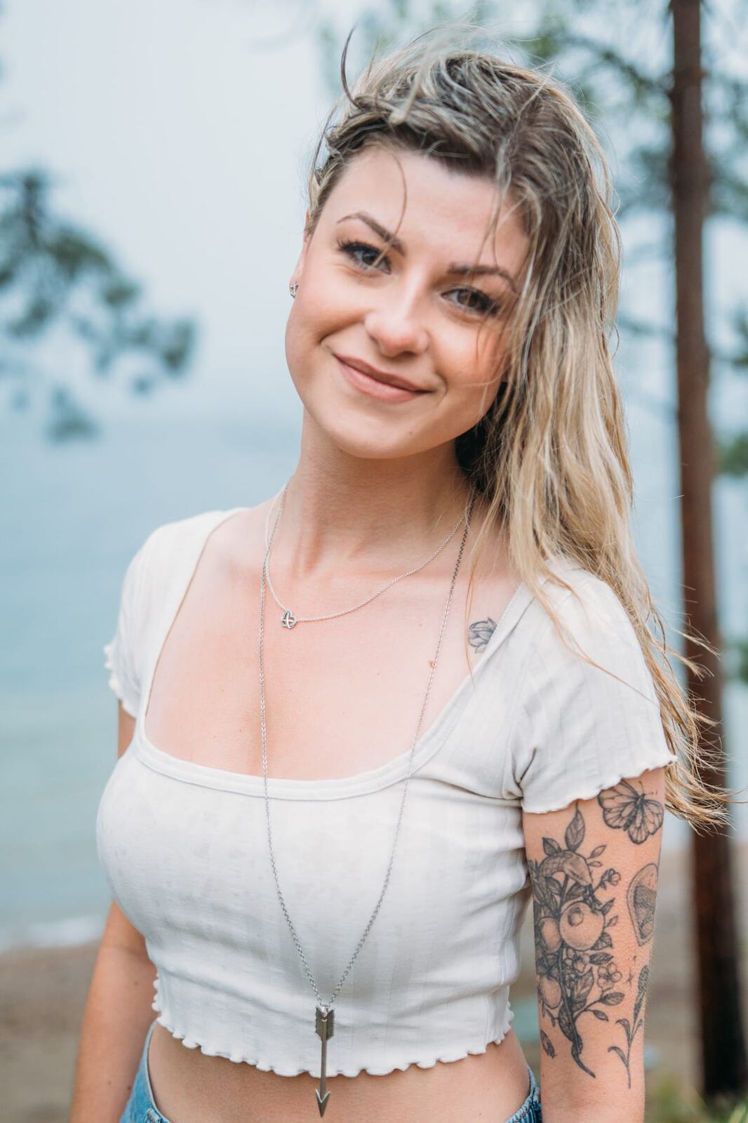 Sophia by the Lake portraits story frame 11: A multi-outfit Okanagan location session with water, trees, shoreline, denim and red swimwear woven into a summer portrait story.