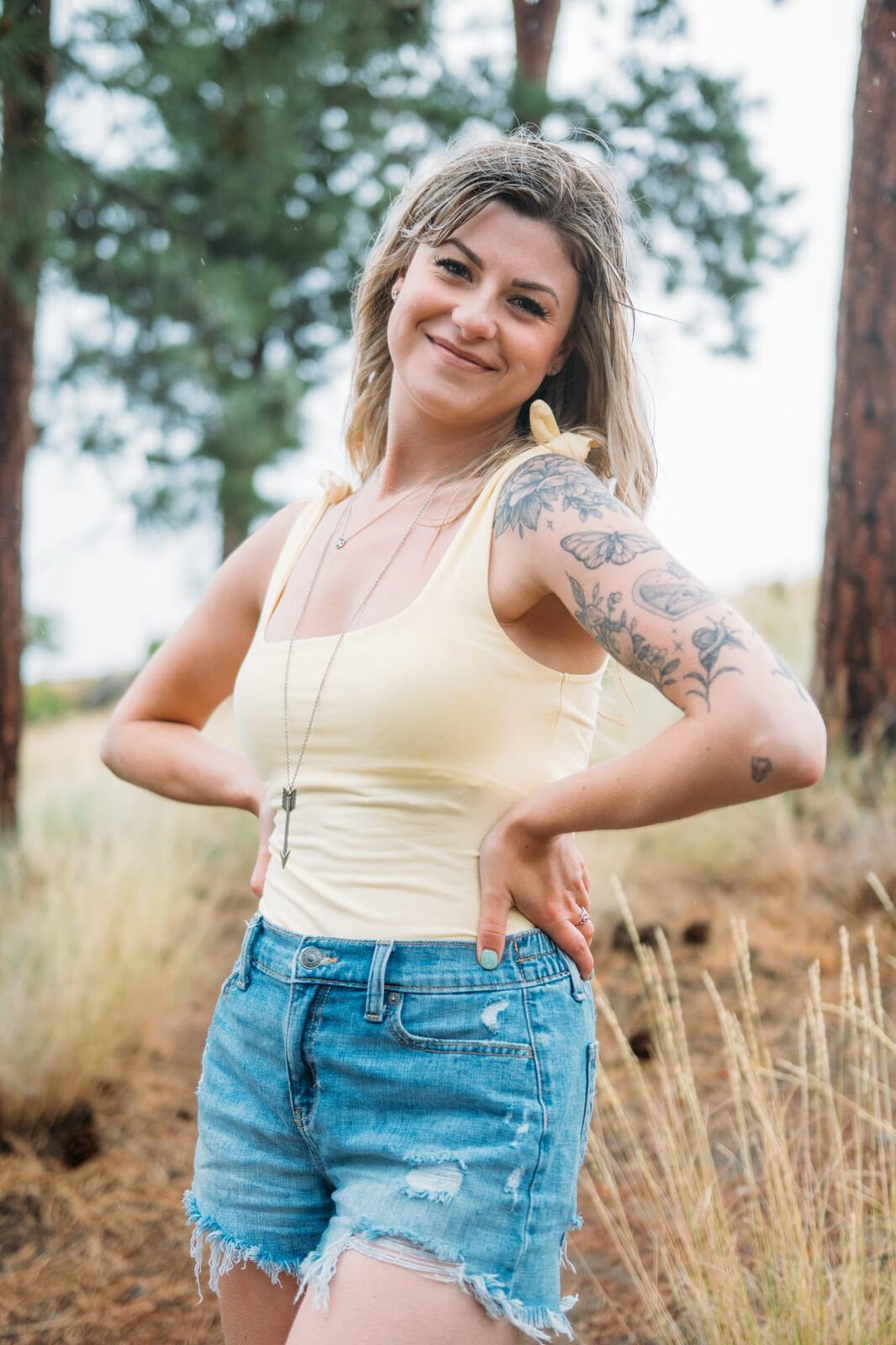 Sophia by the Lake portraits story frame 13: A multi-outfit Okanagan location session with water, trees, shoreline, denim and red swimwear woven into a summer portrait story.