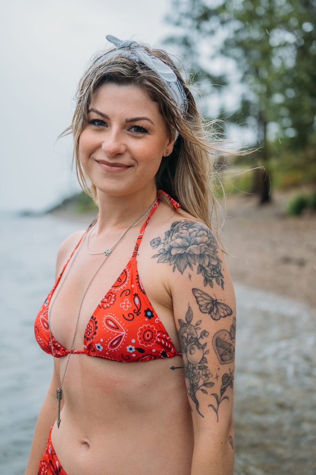 Sophia by the Lake portraits story frame 27: A multi-outfit Okanagan location session with water, trees, shoreline, denim and red swimwear woven into a summer portrait story.