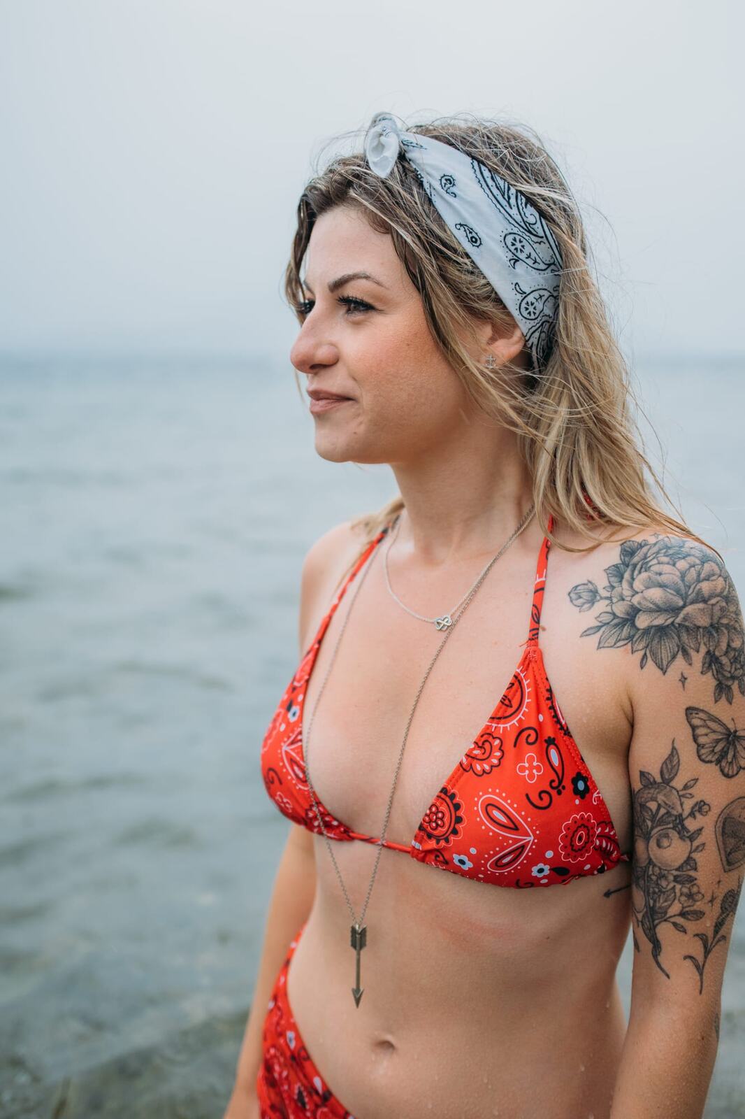 Sophia by the Lake portraits story frame 28: A multi-outfit Okanagan location session with water, trees, shoreline, denim and red swimwear woven into a summer portrait story.
