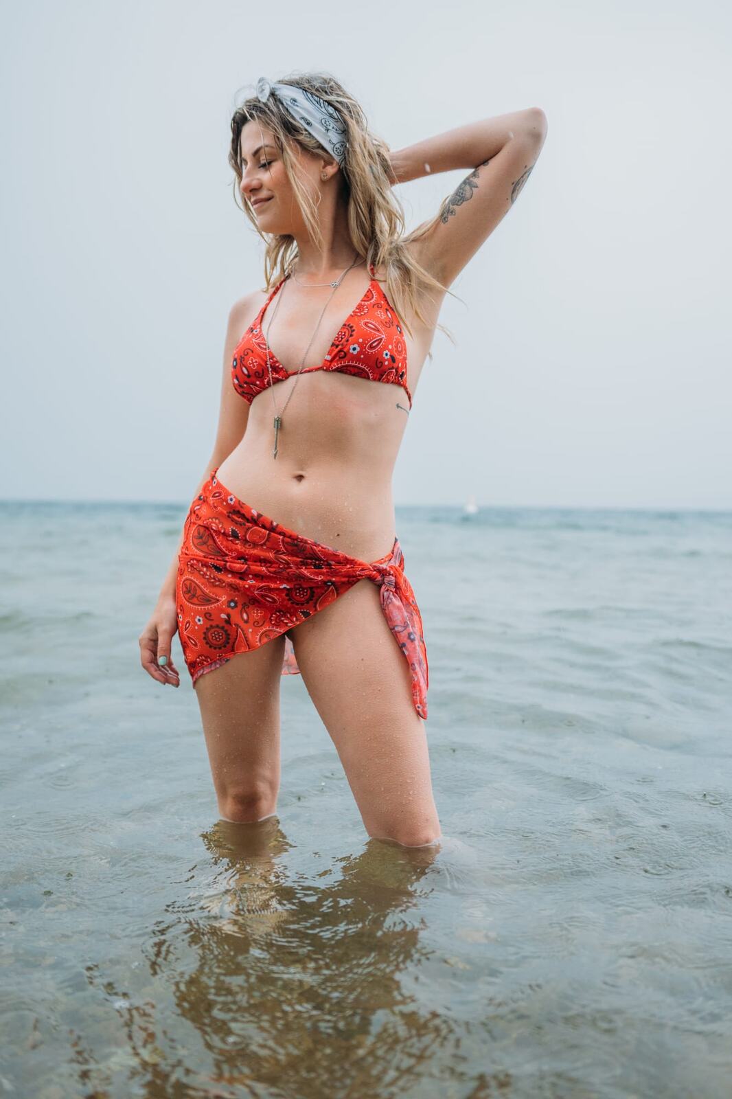 Sophia by the Lake portraits story frame 29: A multi-outfit Okanagan location session with water, trees, shoreline, denim and red swimwear woven into a summer portrait story.