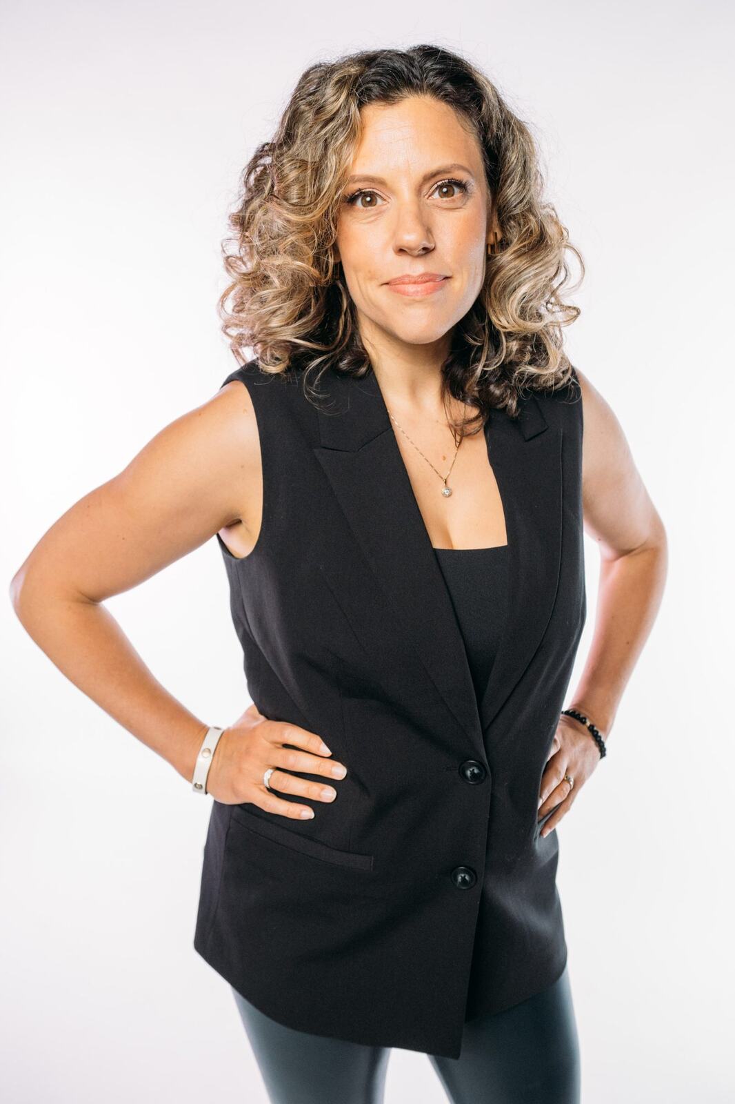 Trisha Miltimore corporate story frame 7: Personal-brand portraits for Trisha Miltimore in Kelowna, moving from clean business profile images into darker wood-wall portraits with black wardrobe and confident brand range..