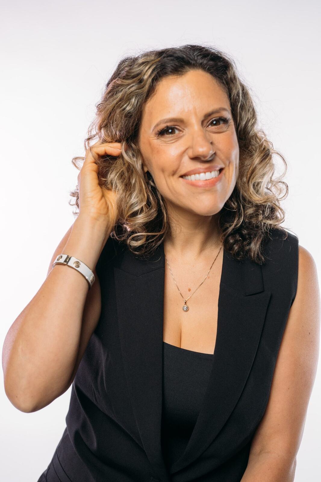 Trisha Miltimore corporate story frame 8: Personal-brand portraits for Trisha Miltimore in Kelowna, moving from clean business profile images into darker wood-wall portraits with black wardrobe and confident brand range..
